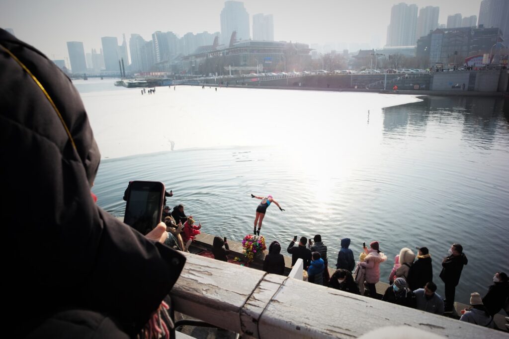 Henkilö tekemässä uimahyppyä avantoon.